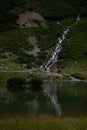 Lake near waterfall in green mountains in Alps Royalty Free Stock Photo