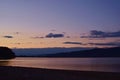 Lake at night reflecting shiny moon on water surface Royalty Free Stock Photo