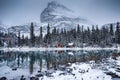 Lake O`hara with wooden hut and snow covered in pine forest on gloomy day at Yoho national park Royalty Free Stock Photo