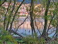 Lake Orestiada and Kastoria city, Greece at sunset time, view through tree trunks