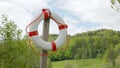 Lake outdoor pool with bathing platform in green landscape with sign in german, german text translation: Schwimmen im See auf