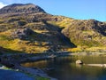 Lake and a pathway with people walking and mountains at the background in Snowdonia National Park in Wales Royalty Free Stock Photo