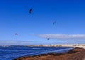 Lake with people parachuting over it in the bright skyline