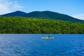 Kayaker enjoy summer day on Lake Placid in New York State`s Adirondack Mountains Royalty Free Stock Photo