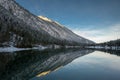 Lake plansee at winter sunrise with mirroring alpine mountain Royalty Free Stock Photo