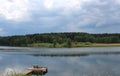 Lake a pond with a pier for fishing in the summer in the forest on the background of a thundercloud river Royalty Free Stock Photo