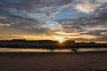 Lake Powell - Silhouette of woman walking with her dog along the shoreline of Lake Powell on Lone Rock Beach in Wahweap, Royalty Free Stock Photo