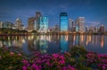 Lake with Purple Flowers in City Park under Skyscrapers at Twilight Royalty Free Stock Photo
