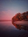 Lake reflecting sunset with colored clouds in the forest