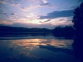 Lake reflecting sunset with colored clouds in the forest