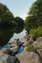 Lake reflections in a evening / Stone and a river in the evening with blue sky