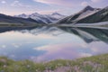 The lake reflects a pastel sky bathed in soft pinks and sapphires.