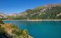 lake of Roselend and blue turquoise water borded by mountains in french Alps Royalty Free Stock Photo