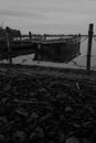 on a lake rowboats lying side by side on shore in water in black white Royalty Free Stock Photo