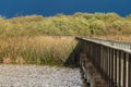 Lake, rushes and marsh plants at the ege of the lake, and an old wooden boardwalk through the lake.