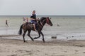 A young guy rides a black horse along the shore of Lake Shalkar in the West Kazakhstan region
