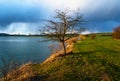 Lake shore, meadow and hill in sunset illumanitaion Royalty Free Stock Photo