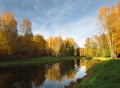 Lake shore in park with calm water and reflection in October