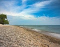 Lake shore with rocky sands and blue sky.