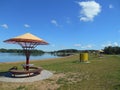 Lake shore summer landscape and bench blue sky background Royalty Free Stock Photo