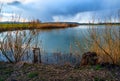 Lake shore in sunset and rain over horizon Royalty Free Stock Photo