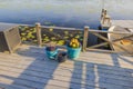 Lake shore view with boat dock and flower pots, adorned with flowers, on wooden pier. Royalty Free Stock Photo