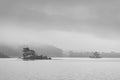 Small island with trees on Ullswater in the Lake District. Taken on a dull misty morning. Black and white landscape photography.