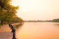 Lake side public park in summer evening. Garden footpath park lane illuminated by sunset sunlight. Red and orange color in Royalty Free Stock Photo
