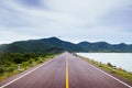 Lake side road with cloudy summer sky and mountain