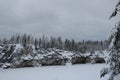 Lake and snow-covered rocks on the background of winter sky Royalty Free Stock Photo