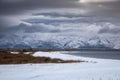 lake with snowy beach and mountain