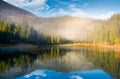 Lake in spruce forest at foggy sunrise Royalty Free Stock Photo