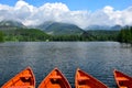 Lake StrbskÃÂ© pleso and a hotel in the High Tatras, Slovakia. Orange boats in front. The ski-jumping hill on the left