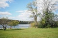 The lake on a sun filled afternoon. The sky is blue with white puffy clouds. The trees are still green. Royalty Free Stock Photo