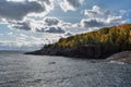 Sun shining on trees changing colors along Lake Superior coastline Royalty Free Stock Photo