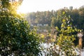 Lake surrounded by trees and minibuses driving in the background