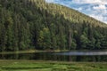 Lake Synevyr in Carpathian mountains, Ukraine. Beautiful mountain lake surrounded by dense green forest on blue sky Royalty Free Stock Photo