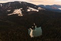 Lake Synevyr framed by a pine forest in the Carpathians, drone view, Synevyr Glade National Nature Park.