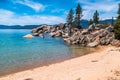 Lake Tahoe Blue lake side water ripples and rocky coastline with Snow capped mountains