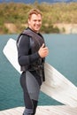 Lake, thumbs up and portrait of man with wakeboard for surfing, exercise and hobby outdoors. Fitness, extreme sports and Royalty Free Stock Photo