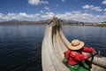 lake titicaca floating islands indigenous woman of the uro culture in long colored skirts with straw hats and braids rowing alone Royalty Free Stock Photo