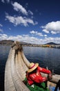 lake titicaca floating islands indigenous woman of the uro culture in long colored skirts with straw hats and braids rowing alone Royalty Free Stock Photo
