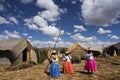 lake titicaca floating islands uros indigenous women in long colored skirts with straw hats and braids waiting for tourists stops