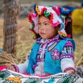 Young peruvian girl wearing traditional clothes on Uros island, Lake Titicaca, Peru Royalty Free Stock Photo