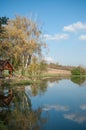 lake with trees in reflection with cloudy sky on backg