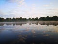 Lake with trees. Summer landscape by the river.Glassy surface of the water