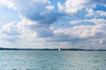 Lake under sky with clouds and sailboat Royalty Free Stock Photo