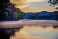 Lake view with colorful trees and blue mountains and sky at sunset Royalty Free Stock Photo