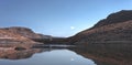 lake view of a dam among the plain of an arid climate with blue sky and few clouds, without people and animals, place of mountain