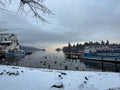Lake Windermere, Lake District in England. Winter with snow. Calm still water with birds boats and swans